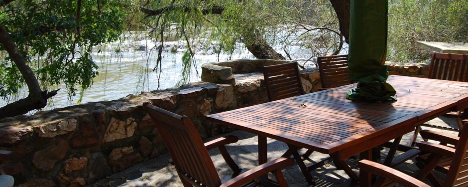Outdoor dining table on the riverbank under shade